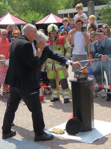 844110 Afbeelding van burgemeester Jan van Zanen die een vlam in een pan dooft tijdens een demonstratie op het grote ...